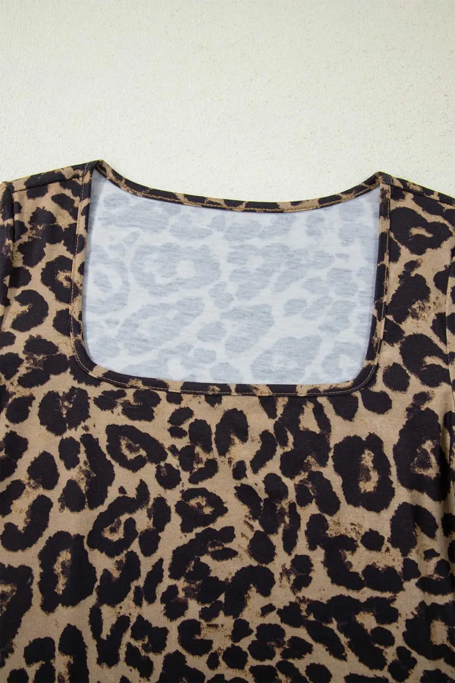 Close-up of leopard print slim long sleeve top neckline, highlighting soft stretch fabric and detailed stitching.