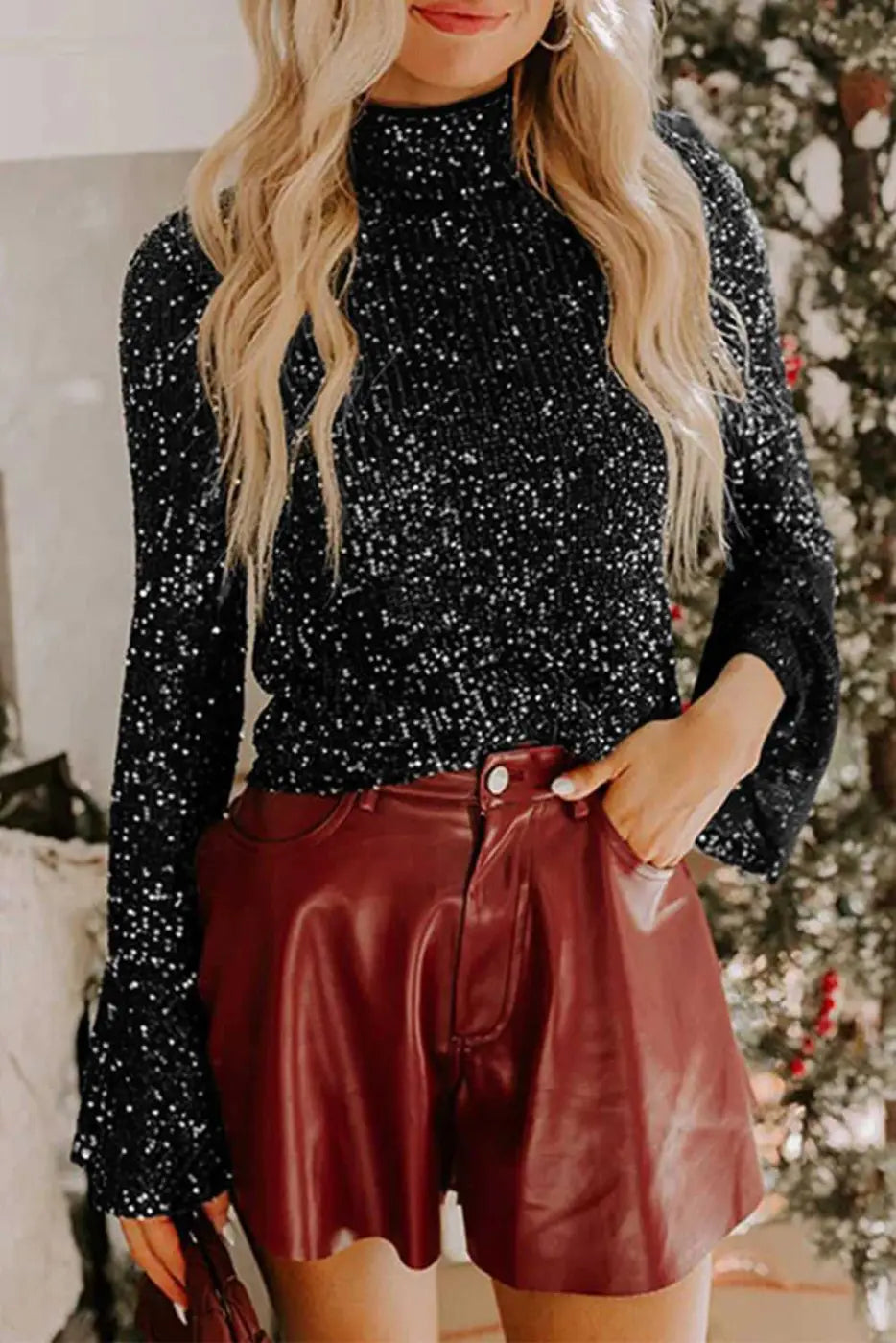 Black sequin bell sleeve blouse styled with red leather shorts, ideal for festive and elegant evening events in the UK.