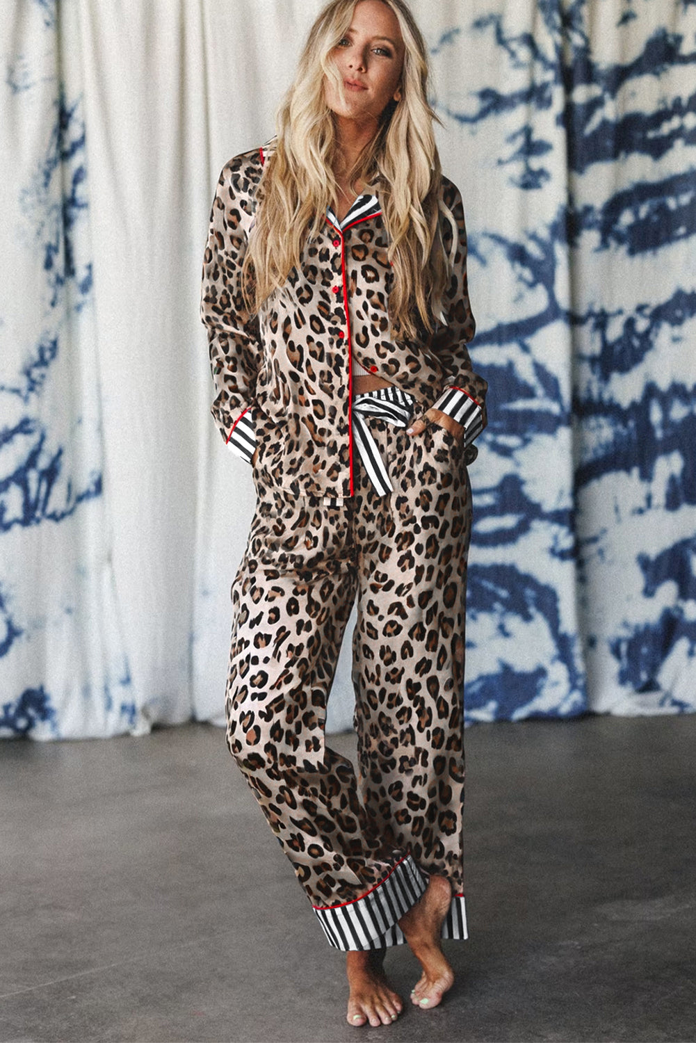 Woman wearing a leopard print lounge set with a colorful zipper against a patterned curtain background.
