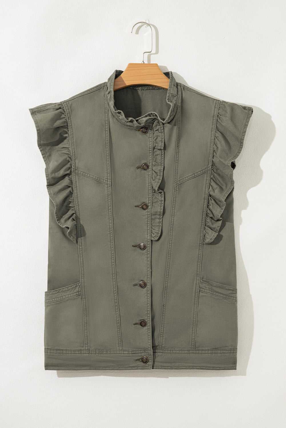 Flat lay of Green Bay Ruffled Denim Vest - Women's Fashion Trends on hanger, showcasing button-down front and structured denim silhouette.
