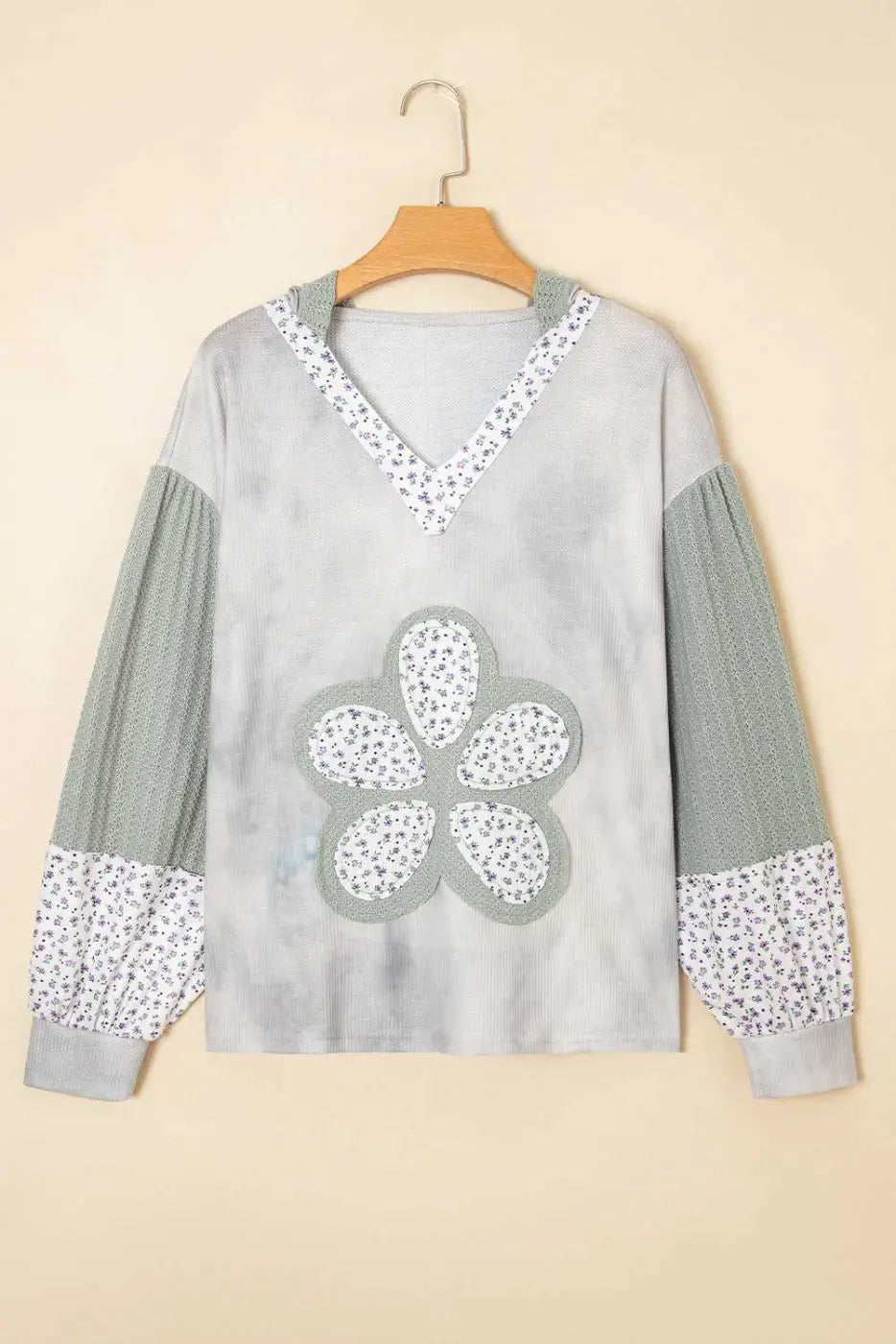 Gray sweater with floral patterns on a beige background
