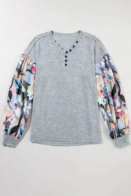 Flat lay of Gray Floral-Sleeves Buttoned V-Neck Top showing full design with colorful sheer sleeves and buttoned neckline.