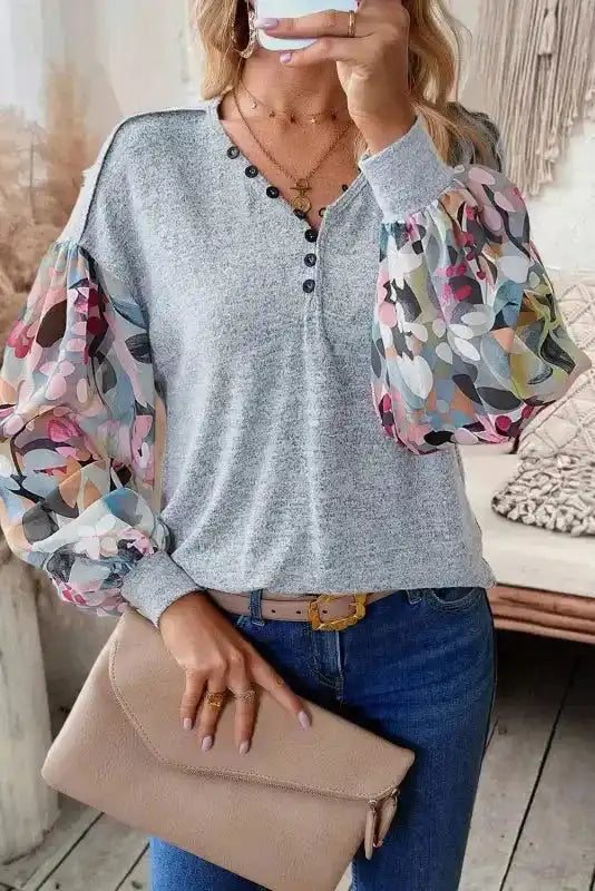 Gray Floral-Sleeves Buttoned V-Neck Top styled with jeans and clutch, showcasing whimsical multicolor balloon sleeves and button neckline.