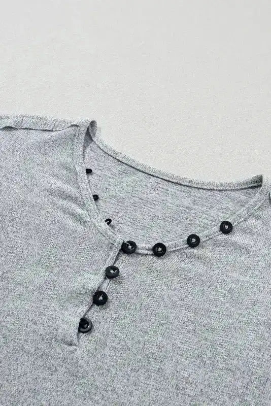 Close-up of buttoned V-neckline on Gray Floral-Sleeves Top, showing detailed stitching and black button accents.