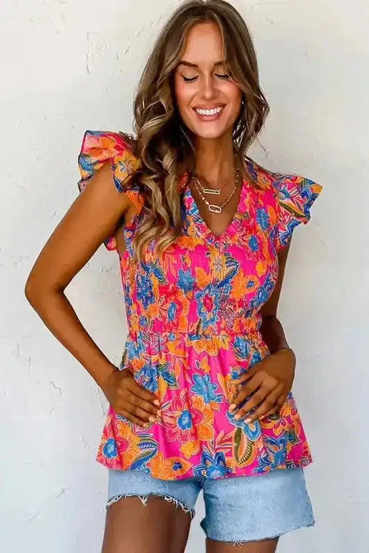 Side view of Floral Smocked Flutter Cap Sleeve Blouse showing V-neckline and flowing flared hem — Fashionfitz