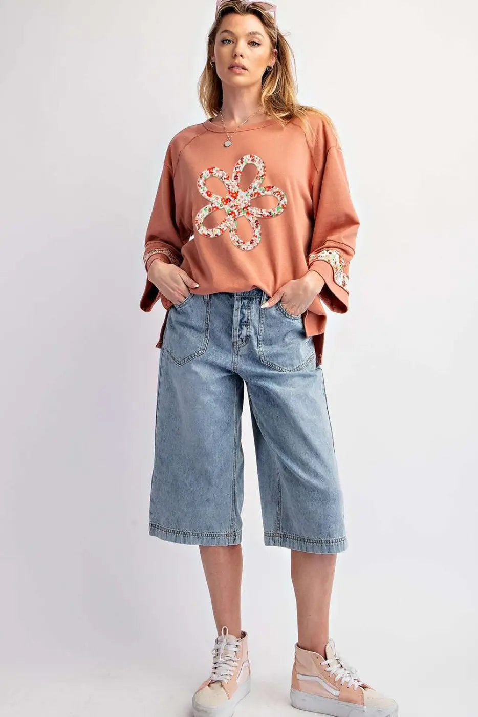 Full-body view of Flower Patch Graphic Top styled with knee-length denim shorts and sneakers, perfect for casual spring fashion.