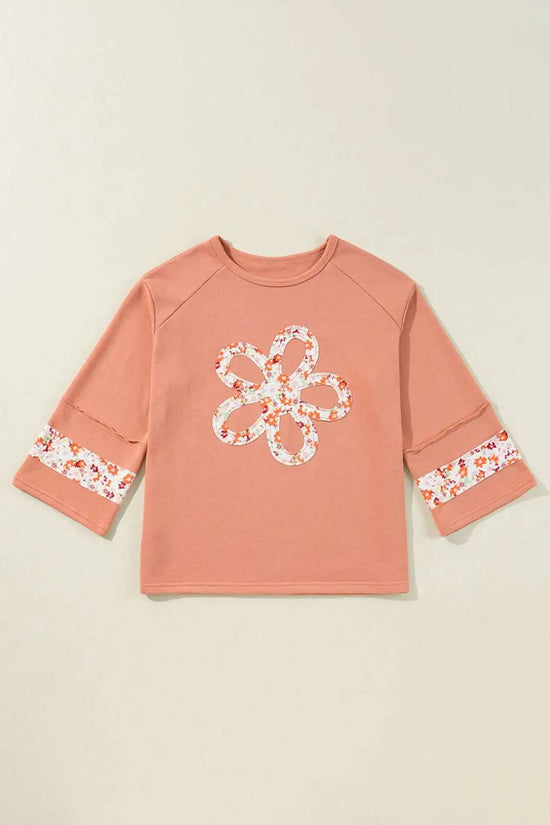 Flat lay of Flower Patch Graphic Top featuring floral patchwork on front and sleeves, showcasing its versatile fit and spring-ready design.