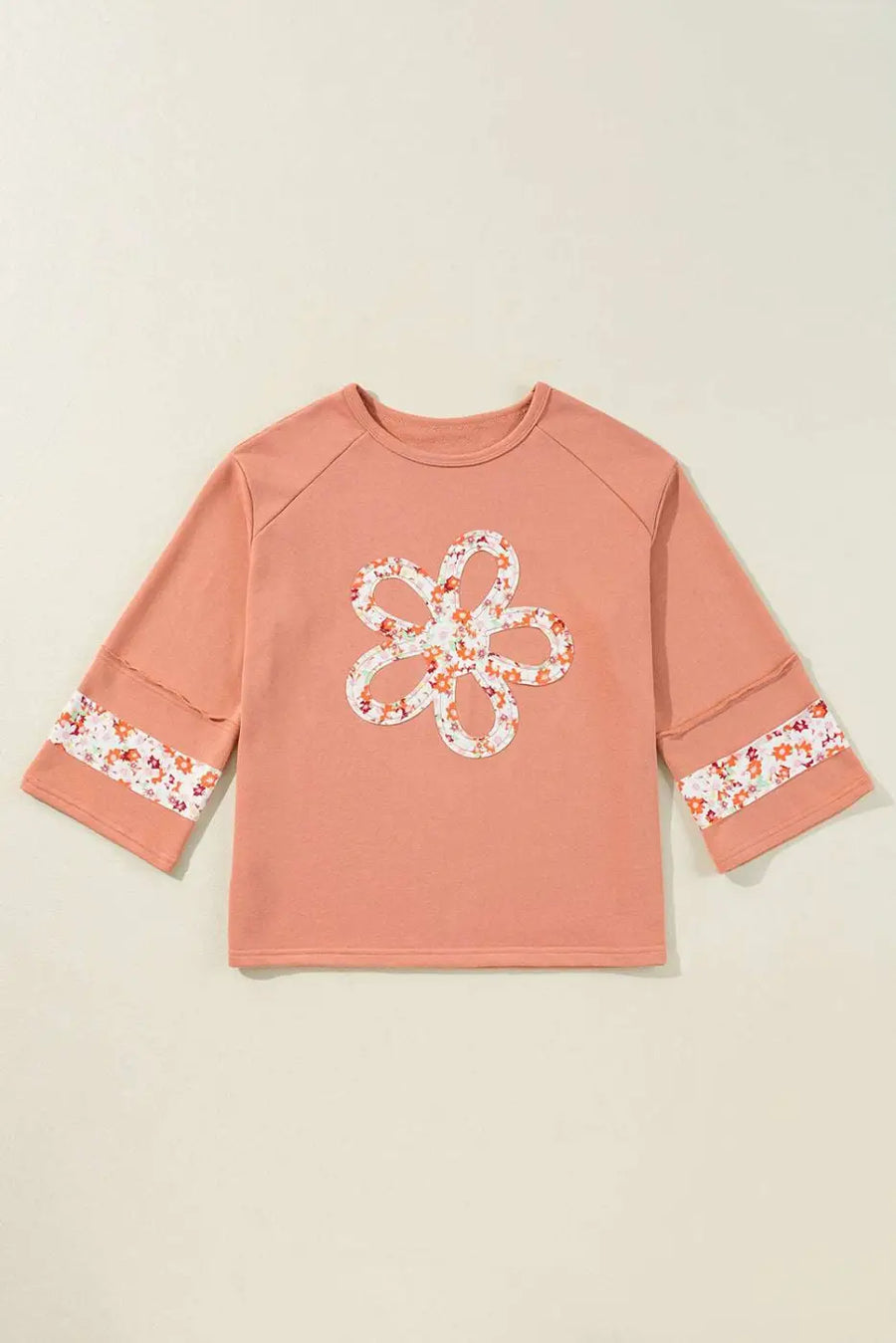 Flat lay of Flower Patch Graphic Top featuring floral patchwork on front and sleeves, showcasing its versatile fit and spring-ready design.