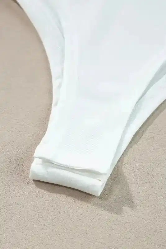 Bottom close-up of white Lace Sleeve Bodysuit showing smooth fabric and clean stitching for a comfortable, secure fit.