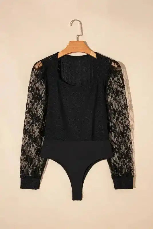 Flat lay of Elegant Lace Sleeve Bodysuit on hanger, showcasing sheer lace sleeves and snap closure bottom.