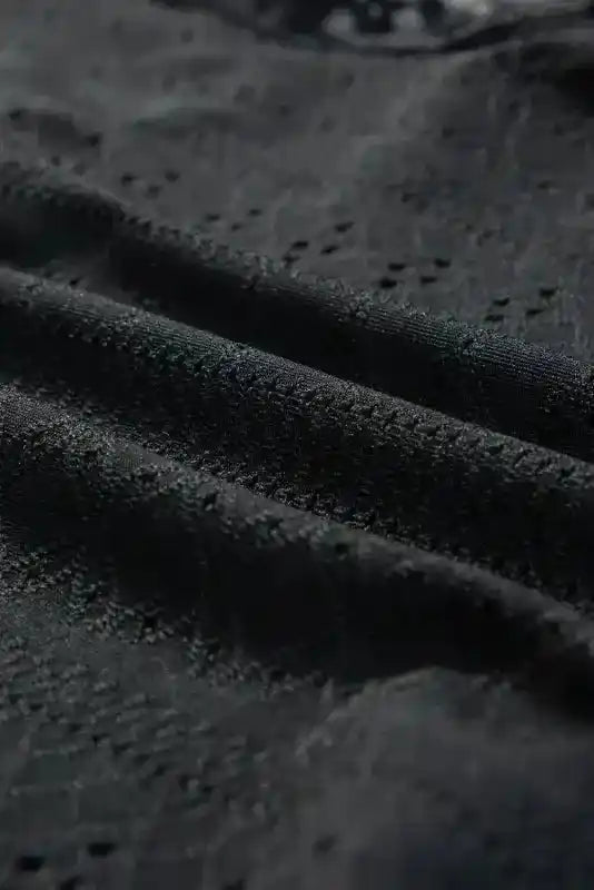 Close-up of black lace fabric texture from the Lace Sleeve Bodysuit, showcasing intricate embroidery and soft material for elegant style.