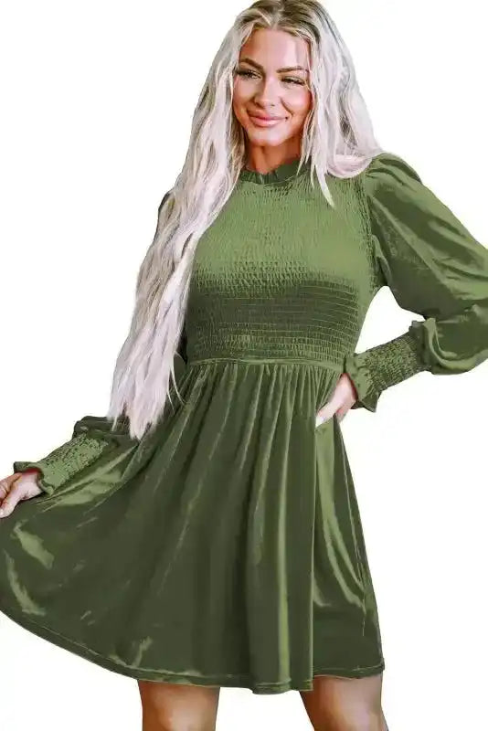 Isolated view of model in green Frilled Neck Smocked Bodice Velvet Dress, showcasing flattering fit and festive style.