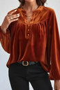 Gold Flame Beaded Velvet Top with long sleeves and split V-neck, styled with black jeans for a chic winter look.