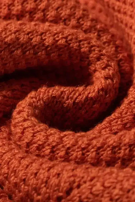 Macro shot of rust textured knit fabric, emphasizing breathable and stretchable summer sweater material.