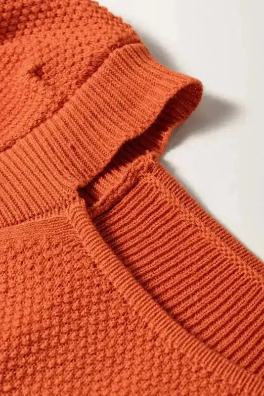 Detailed view of square neckline and textured knit pattern of rust bubble sleeve crop top, highlighting breathable fabric.