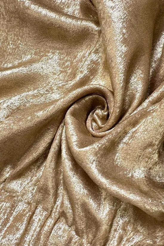 Close-up of gold metallic shimmer fabric used in women's high waist shorts, showcasing texture and luxurious finish for summer fashion.