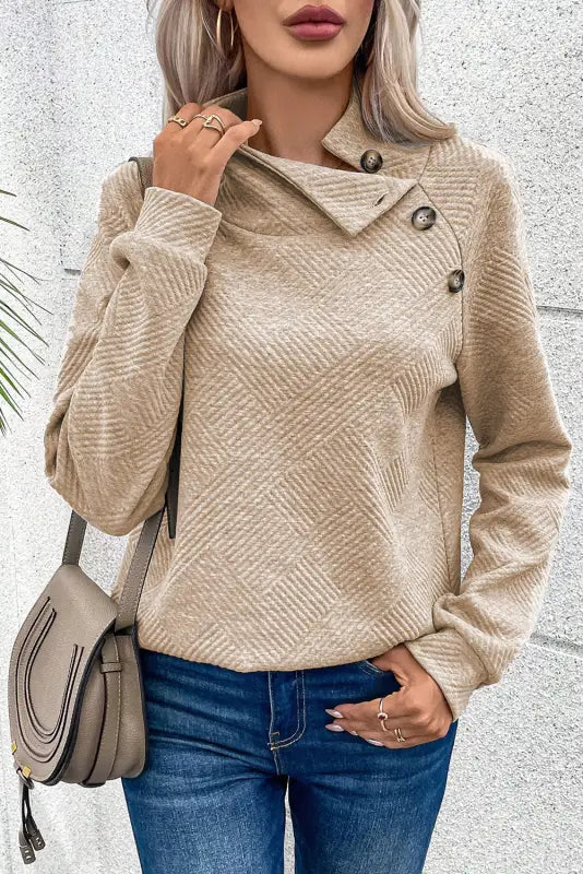 Gray high neck textured sweatshirt with an asymmetrical collar and decorative buttons