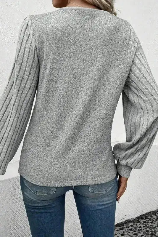 Back view of V-neck Ribbed Bishop Sleeve Top in grey, featuring ribbed sleeves and soft knit fabric.