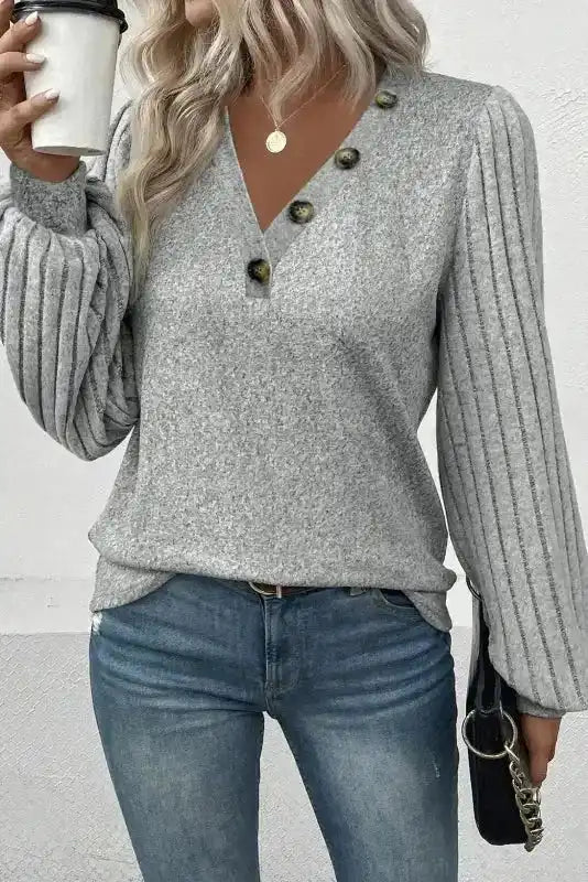 V-neck version of Ribbed Bishop Sleeve Top in grey with decorative buttons, styled with jeans for a trendy look.