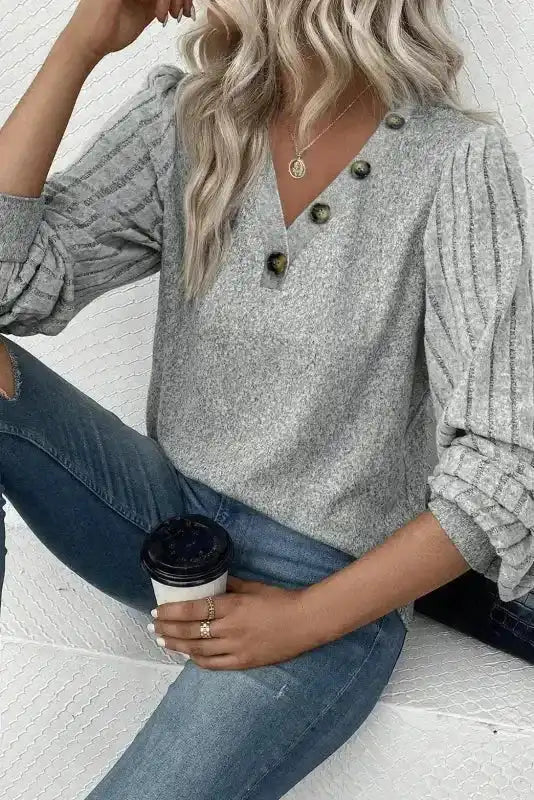 Comfy grey ribbed bishop sleeve sweater paired with jeans, showcasing a casual fall look with button detail and soft knit fabric.