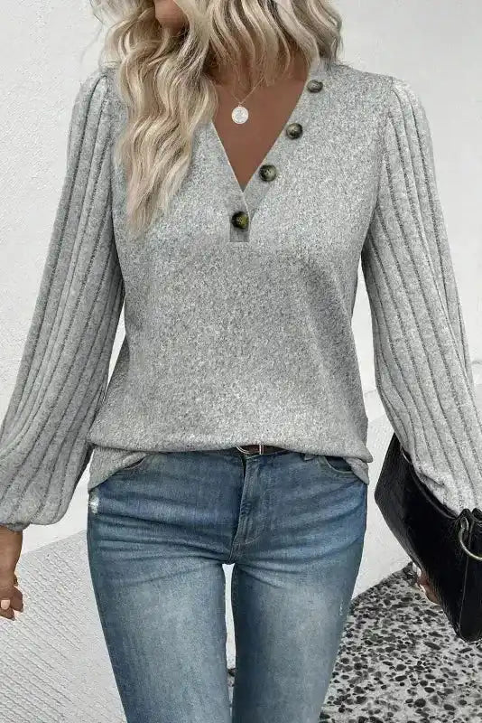 Stylish grey ribbed bishop sleeve top featuring a V-neckline and textured knit, perfect for daily wear in autumn.