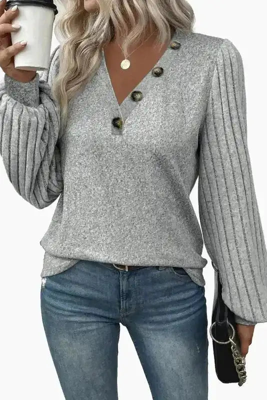 Grey ribbed bishop sleeve top with unique button accents and relaxed fit, a cozy and chic choice for autumn fashion.
