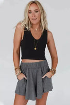 Model wearing gray elastic waist Lambada shorts with a black tank top, showing a chic and comfy summer fashion option.