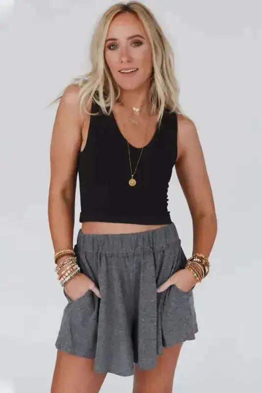 Model wearing gray elastic waist Lambada shorts with a black tank top, showing a chic and comfy summer fashion option.