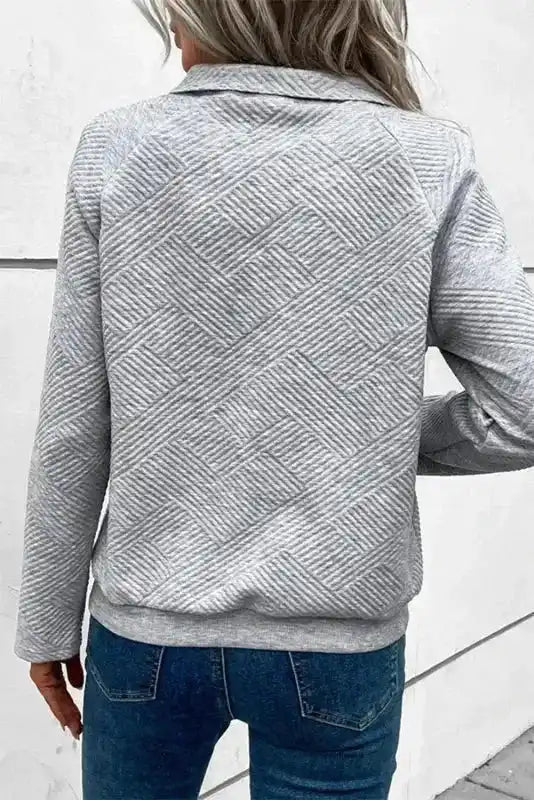 Back view of gray ribbed pullover top with geometric texture and relaxed fit, ideal for casual winter wear.