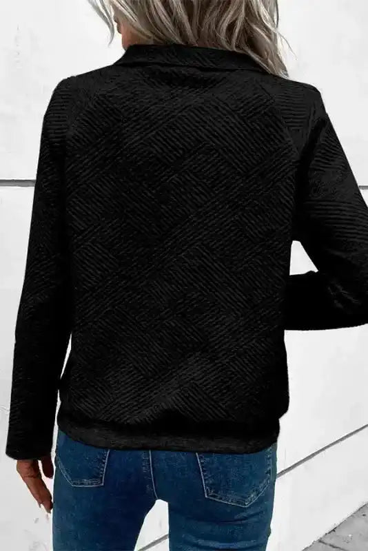 Back view of black ribbed pullover sweater featuring geometric textured pattern and long sleeves, ideal for daily winter wear.