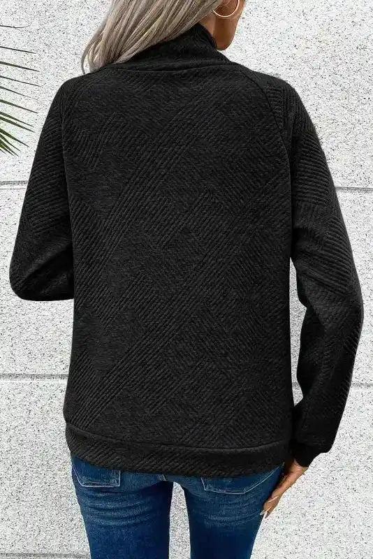 Back view of black geometric textured pullover sweater, showcasing ribbed fabric and relaxed fit for daily winter wear.