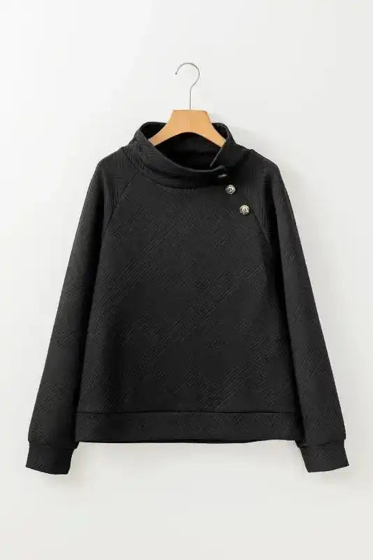 Flat lay of black ribbed pullover sweater with button collar and geometric texture, perfect for winter casual wear.