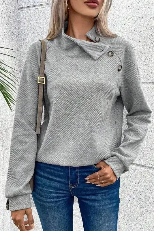 Gray ribbed pullover top with buttoned high collar and long sleeves, styled for casual winter occasions.
