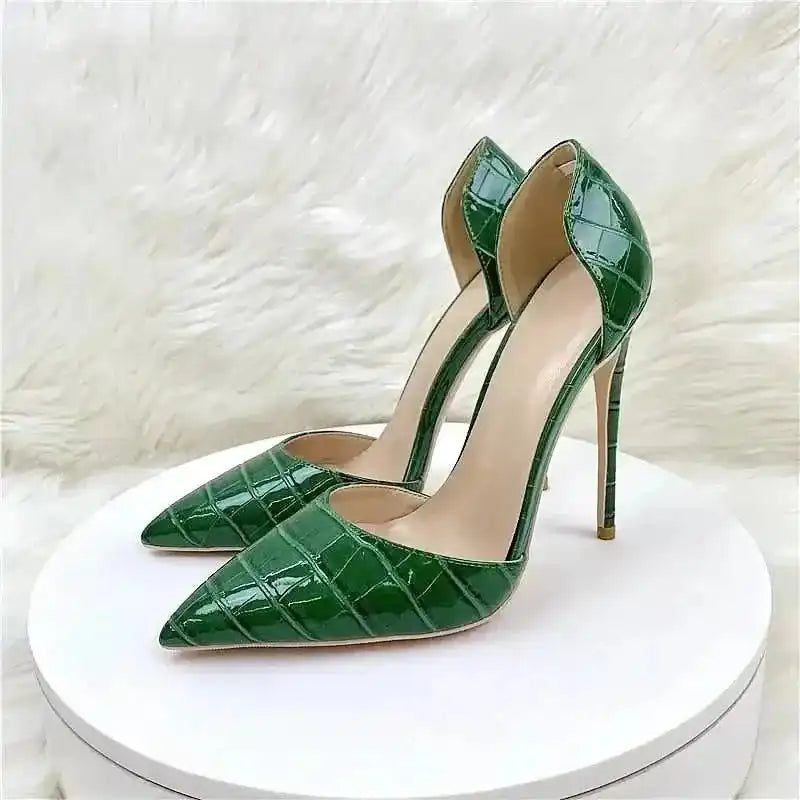 Croc-effect green stilettos displayed on white round platform with fur background, highlighting their glossy finish and chic design.