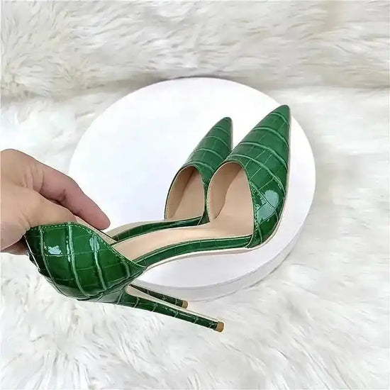 Hand holding croc-effect green stiletto heel to show detailed PU leather texture and pointed toe, perfect for special occasions.
