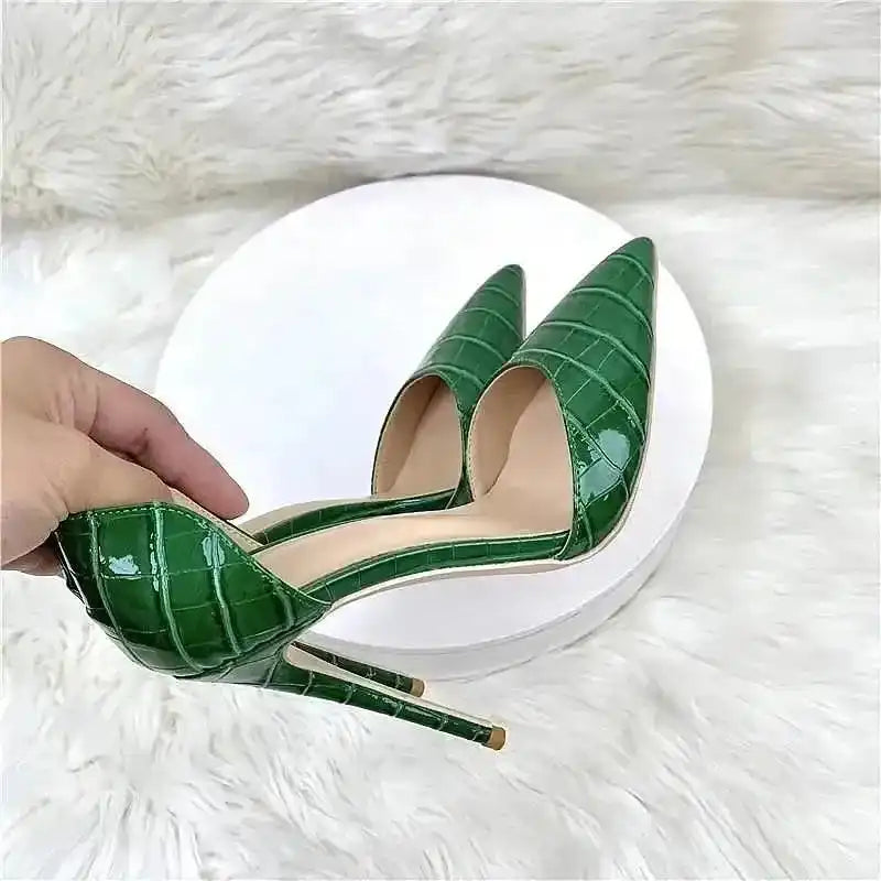 Hand holding croc-effect green stiletto heel to show detailed PU leather texture and pointed toe, perfect for special occasions.