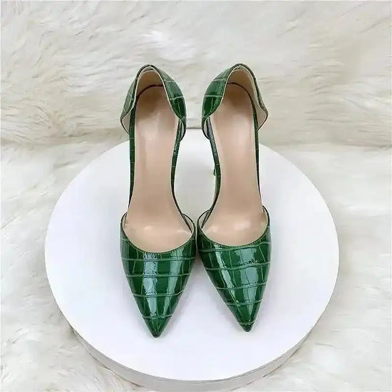 Front view of croc-effect green stilettos on white platform, highlighting pointed toe and PU leather texture for formal occasions.