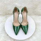 Front view of croc-effect green stilettos on white platform, highlighting pointed toe and PU leather texture for formal occasions.