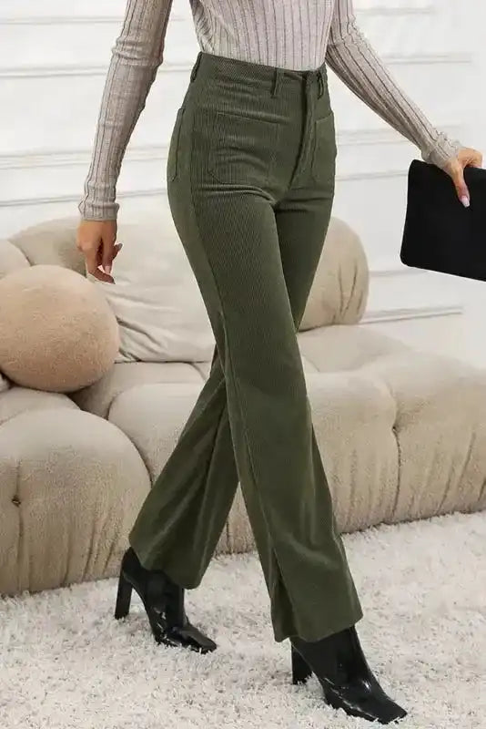 Side view of green corduroy pants women featuring high waist and flared leg design. Stylish vintage trousers perfect for western or retro looks.