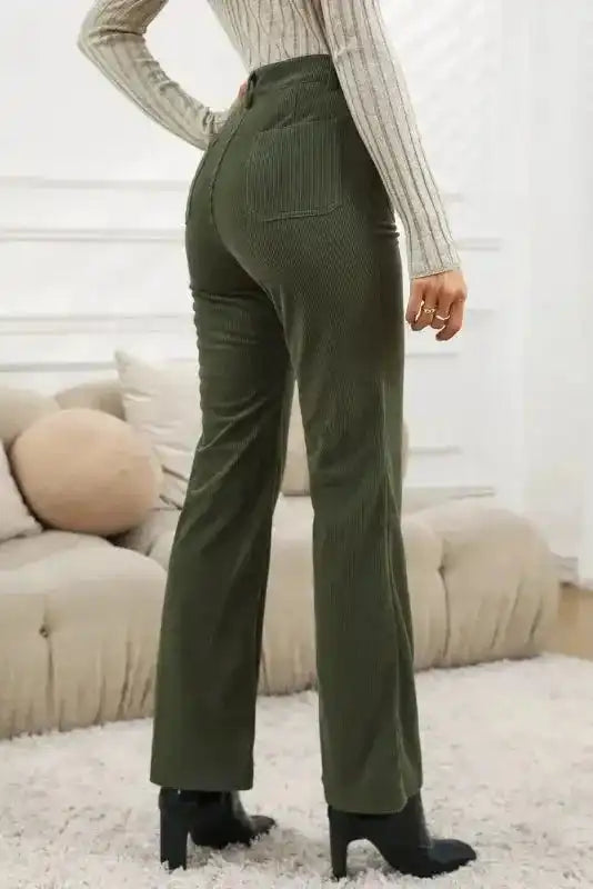 Back view of green high waist corduroy pants women with square pockets. Retro-inspired solid green trousers styled for casual daily outfits.