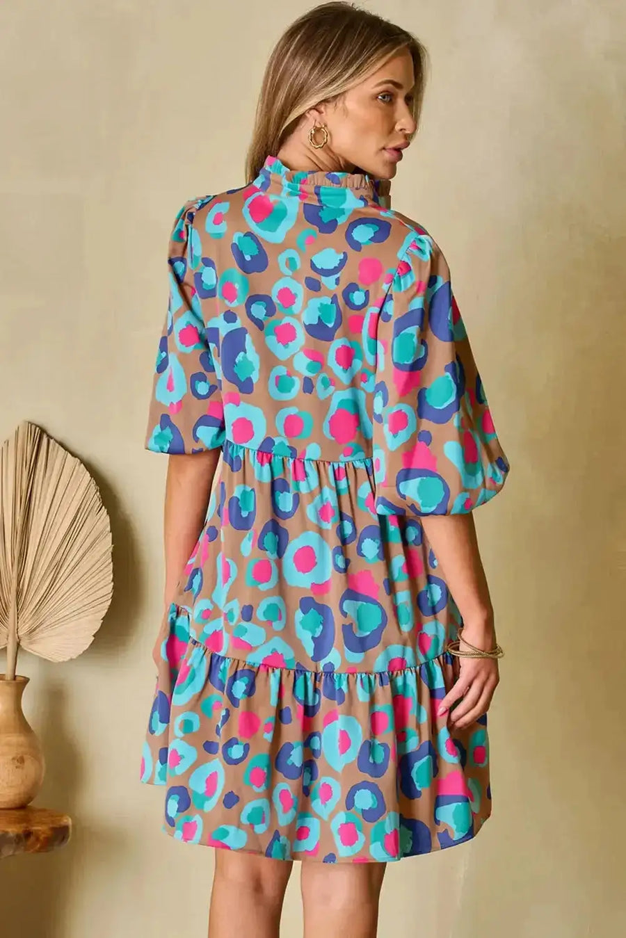 Back view of multi-colour tiered mini dress with bubble sleeves, highlighting tiered layers and vibrant print for a chic statement look.