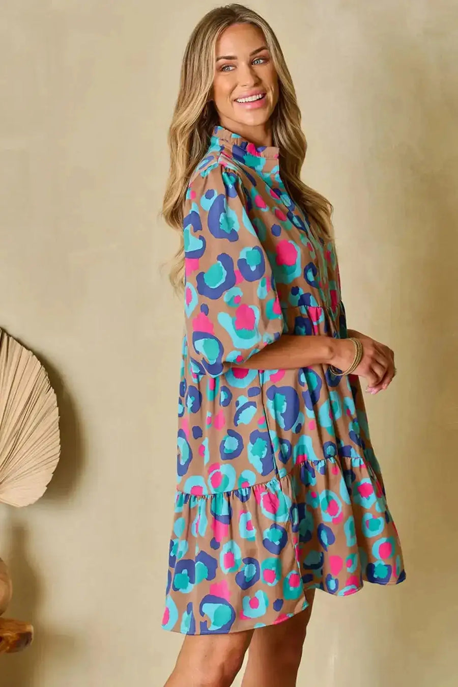 Side profile of multi-colour tiered dress with bubble sleeves, featuring relaxed fit and bold pattern for fashionable everyday wear.
