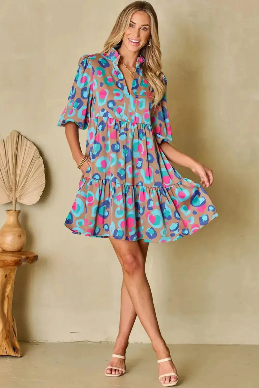 Model wearing multi-colour tiered dress with bubble sleeves, showcasing playful silhouette and bold hues ideal for casual UK fashion.