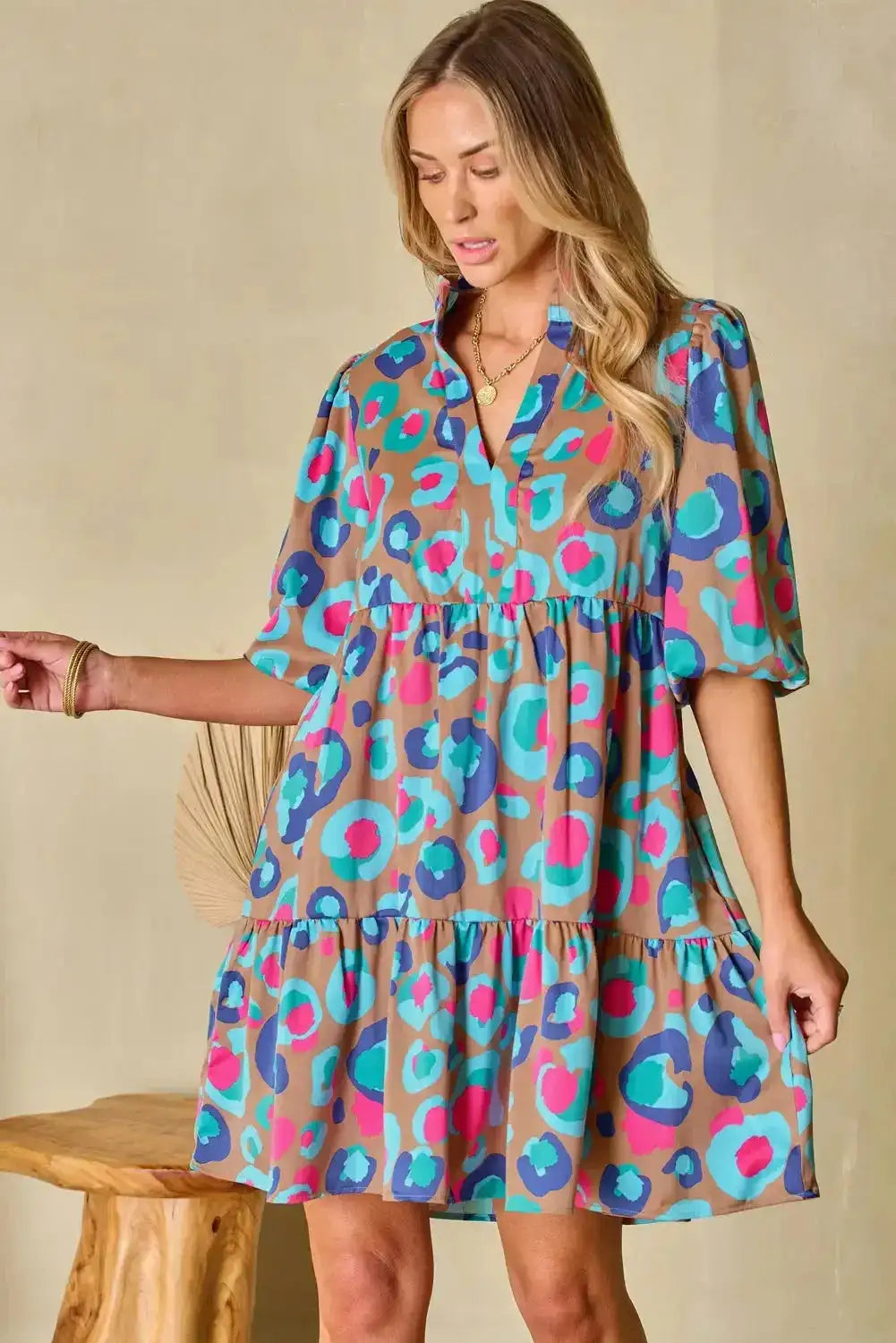 Woman wearing colourful tiered dress with bubble sleeves and v-neck, ideal for vibrant and comfortable mini dress styling.