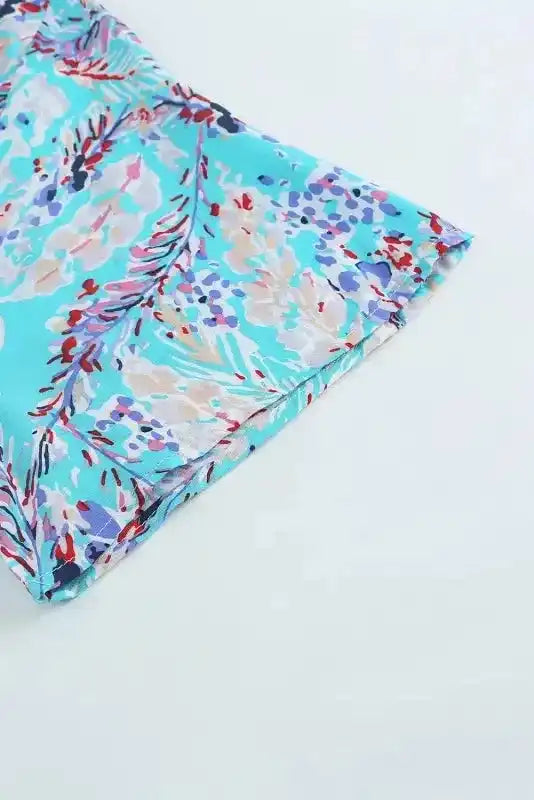 Close-up of hem detail on green floral maxi dress with abstract print and lightweight fabric, ideal for summer wear.