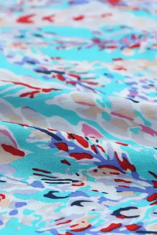 Fabric texture of green floral maxi dress with abstract multicolor print, highlighting breathable material for summer comfort.