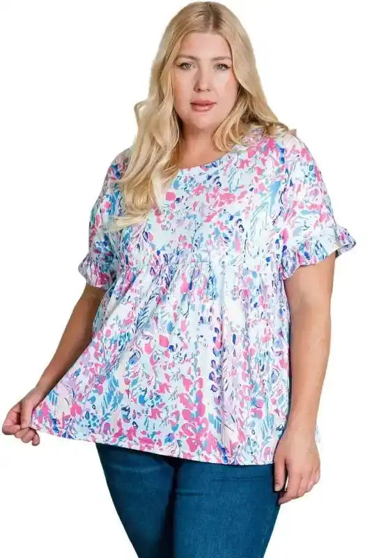 Plus size floral short sleeve top with ruffle cuffs in pink, blue, and white abstract print, ideal for casual summer wear.