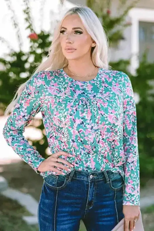 Front view of green floral long sleeve top with gathered neckline, styled with jeans for a casual fall look.