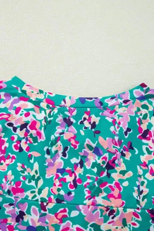 Back neckline detail of green floral top with vibrant abstract print, showcasing seam and fabric texture.