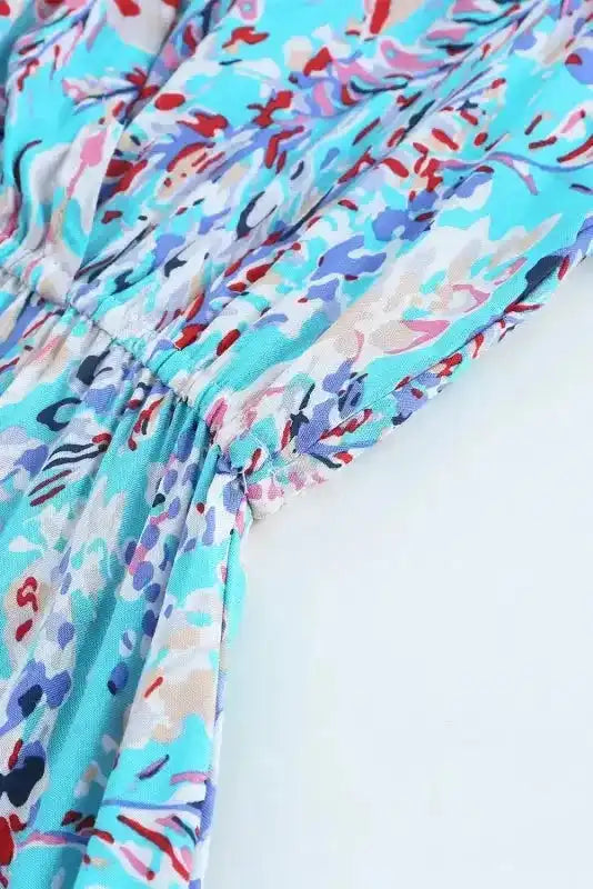 Elastic waist detail on green wrap-style floral maxi dress with v-neck, showcasing flattering fit and vibrant print.